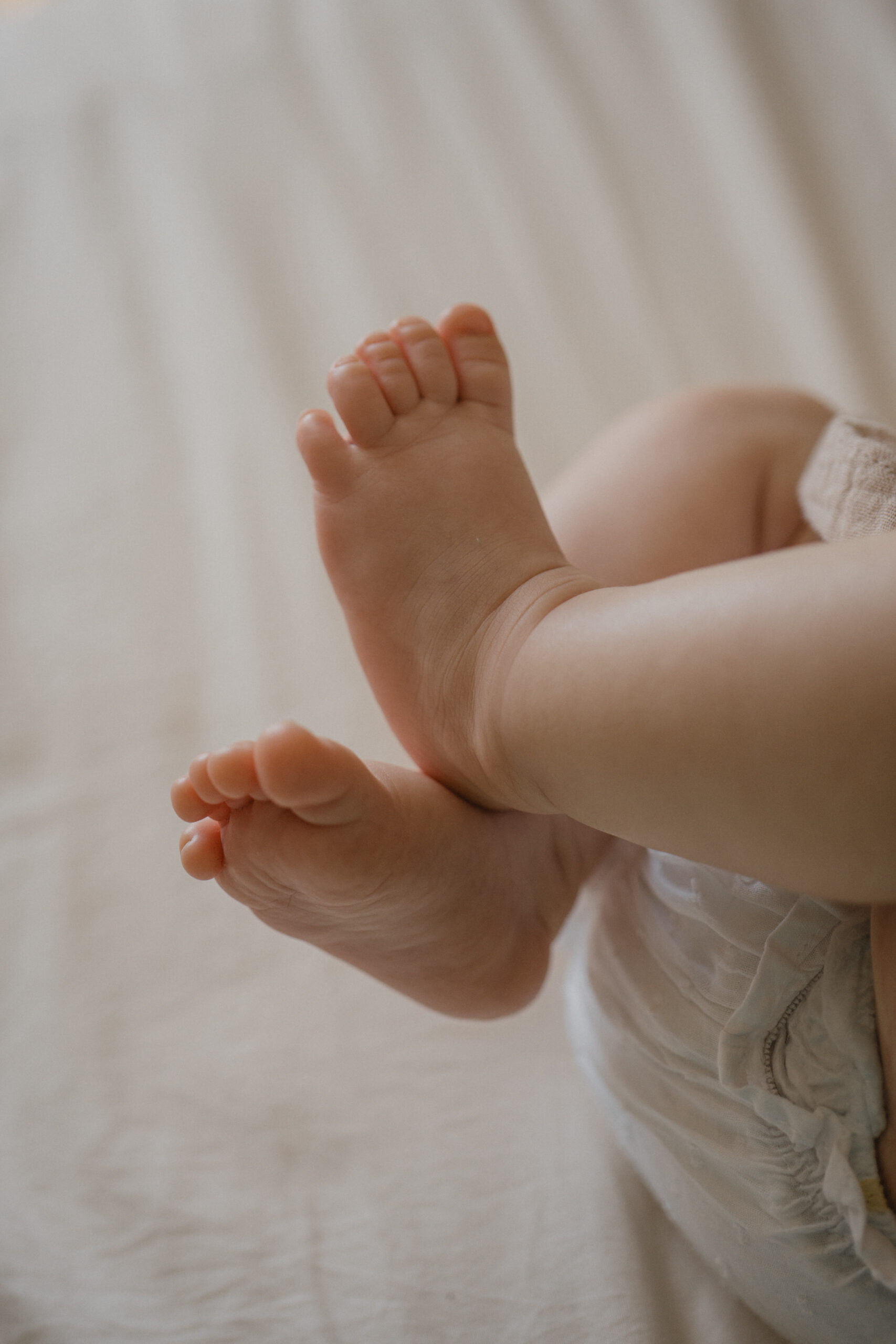 Gros plan sur les petits pieds d'un nouveau-né pendant une séance photo naissance.