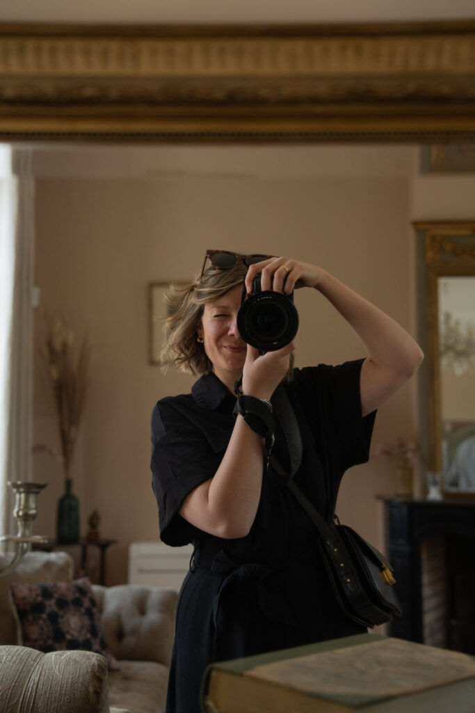 La photographe se capture dans un miroir pendant les préparatifs.