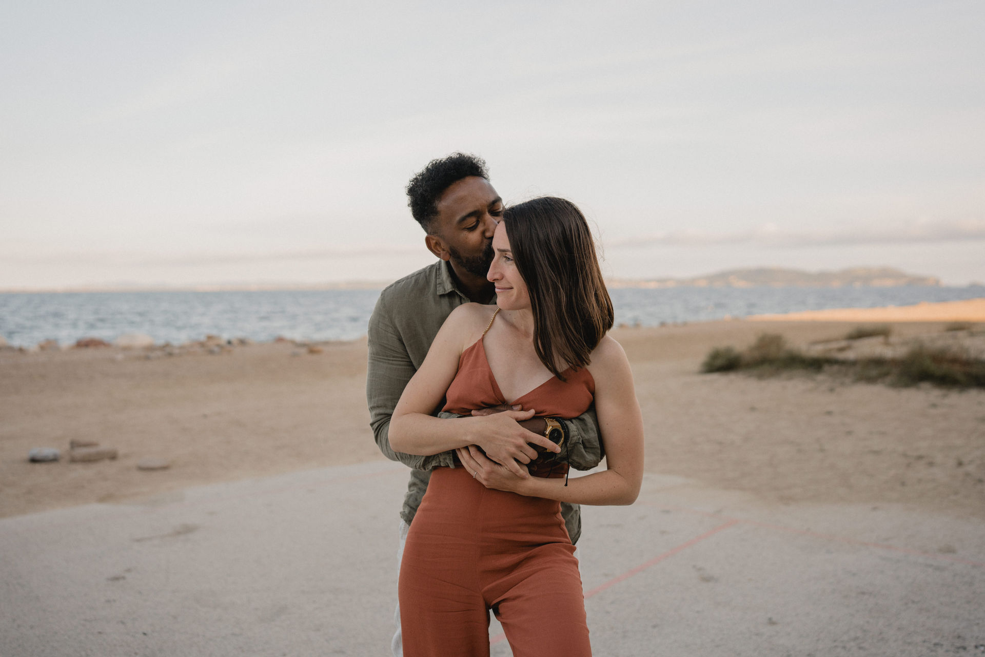 Couple enlacé au bord de la mer pendant une séance photo