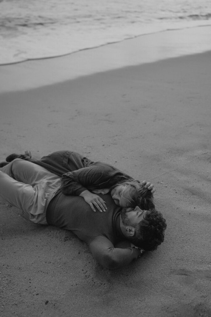 Couple allongé sur une plage en noir et blanc