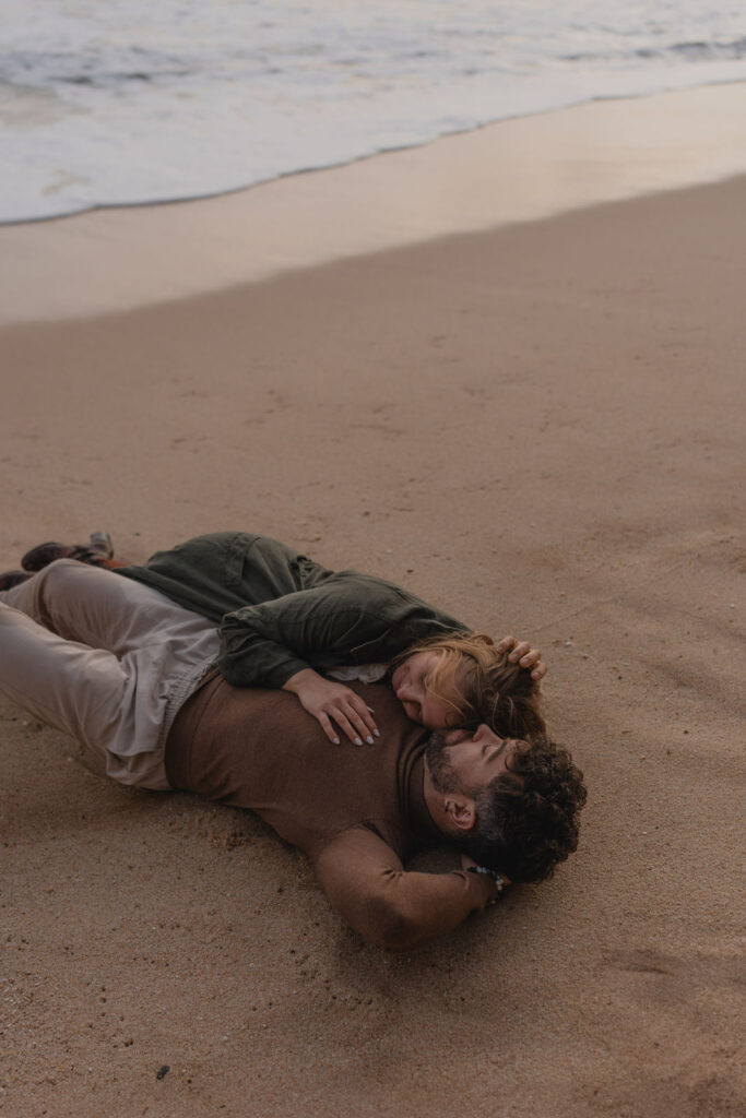Couple allongé sur le sable lors d'une séance photo