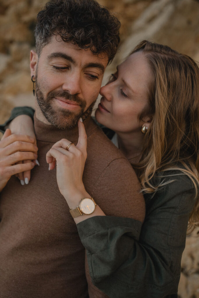Couple enlacé sur une plage rocheuse