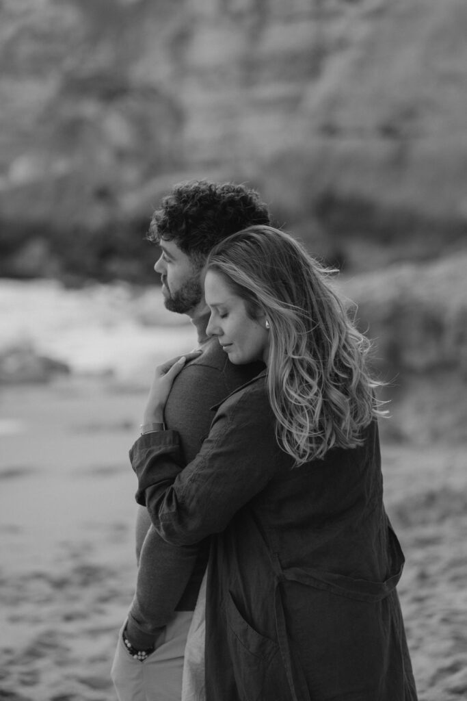 Couple enlacé sur une plage en noir et blanc