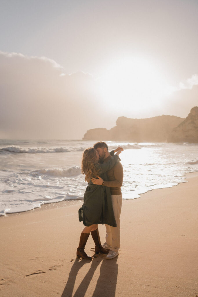 Couple s'embrassant sur la plage au coucher du soleil