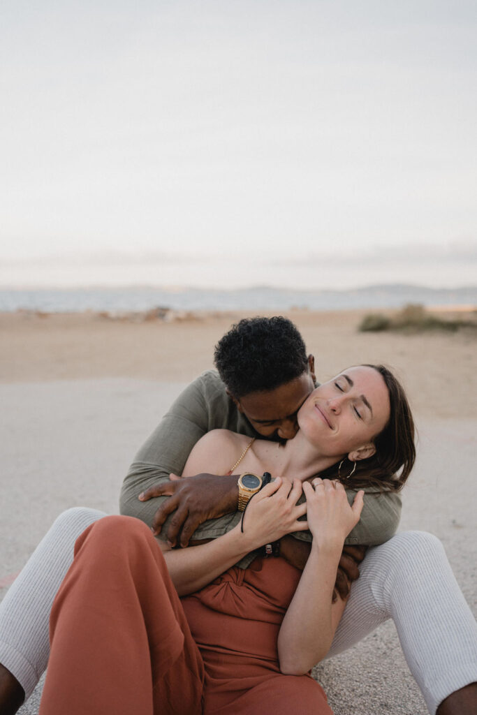 Couple enlacé lors d'une séance photo en bord de mer