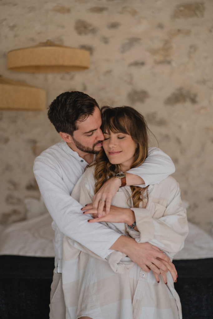 Couple enlacé dans une chambre lors d'une séance photo lifestyle