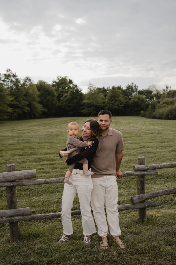 Jeunes parents avec leur enfant dans un parc au coucher du soleil