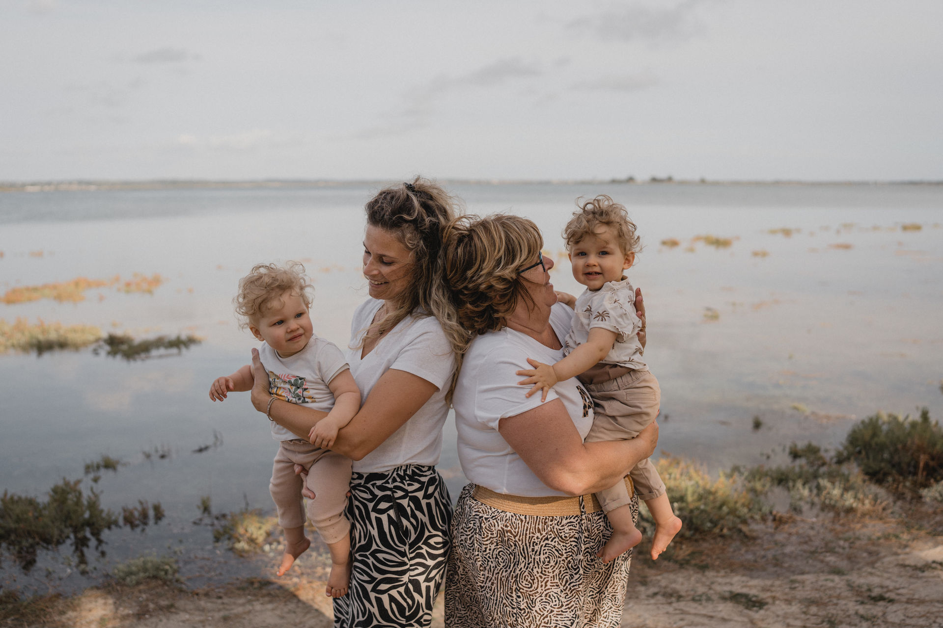 3 générations réunions sur une seule photo : grand-mère, maman et les jumeaux au bord de l'eau