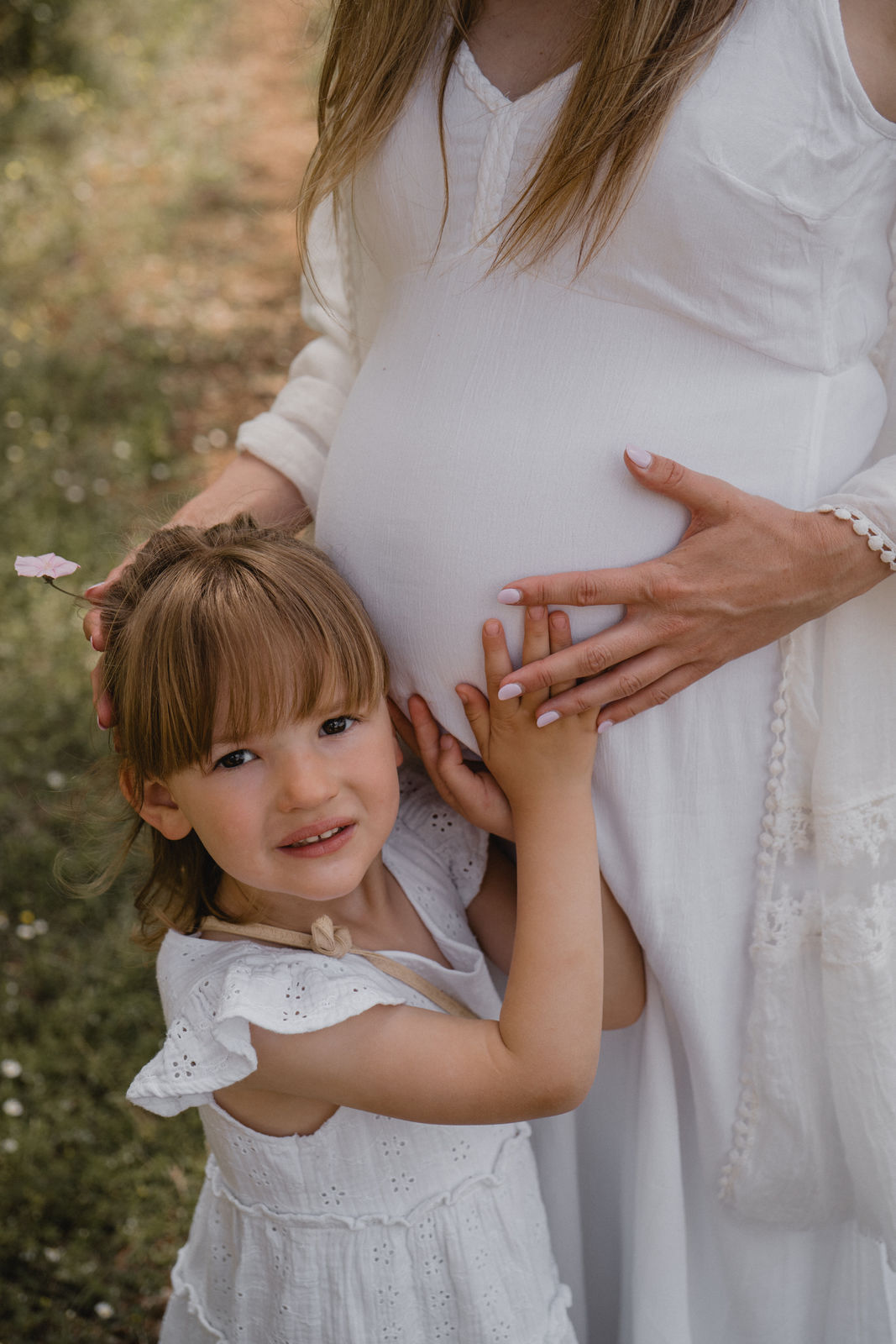 Petite fille touchant le ventre de sa maman enceinte