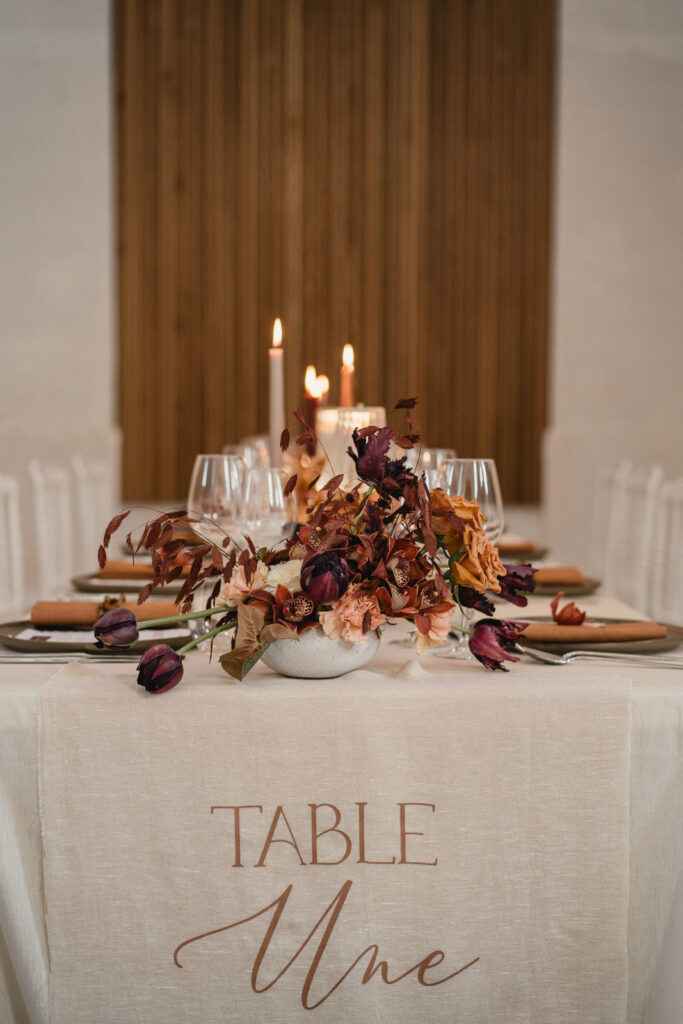 Table de réception décorée de fleurs, bougies et vaisselle pour le dîner de mariage.