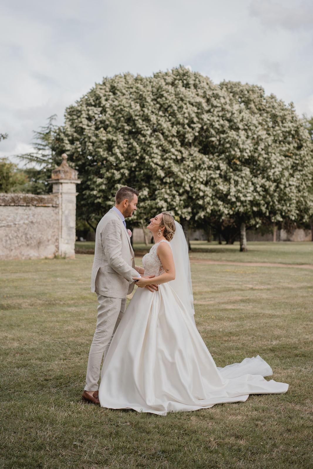 Jeunes mariés se tenant la main dans le parc de leur château de mariage