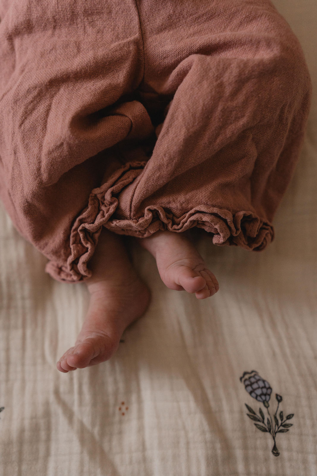 Gros plan sur les petits pieds d'un nouveau-né dépassant de sa gigoteuse.