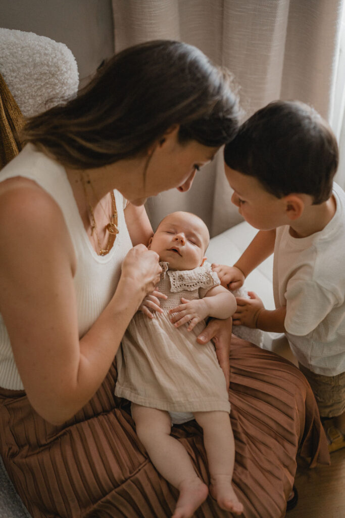 Maman regardant son nouveau-né entouré de sa famille