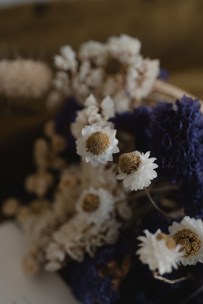 Bouquet de fleurs séchées posé à côté d'une carte cadeau