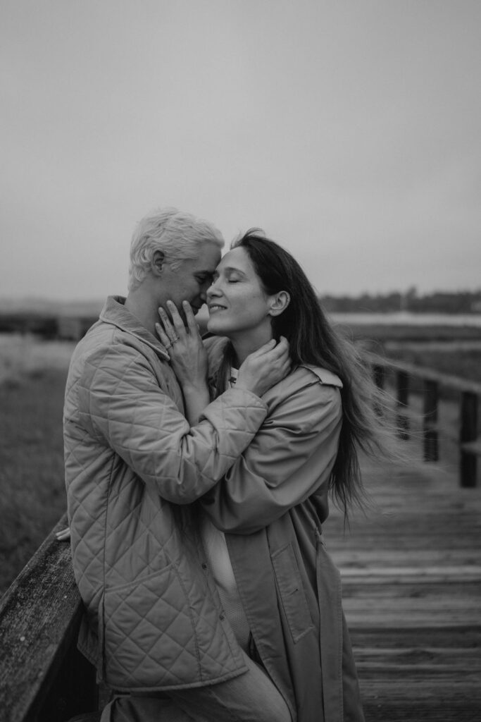 Couple s'embrassant sur une jetée en noir et blanc