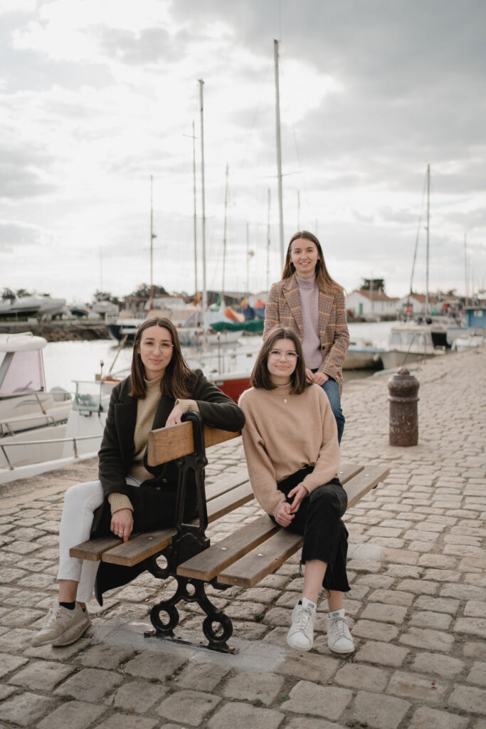 Trois soeurs assises sur un banc près d'un port à Noirmoutier