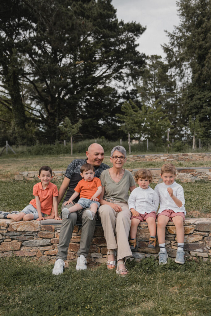 Grands-parents entourés de leurs petits-enfants assis sur un muret