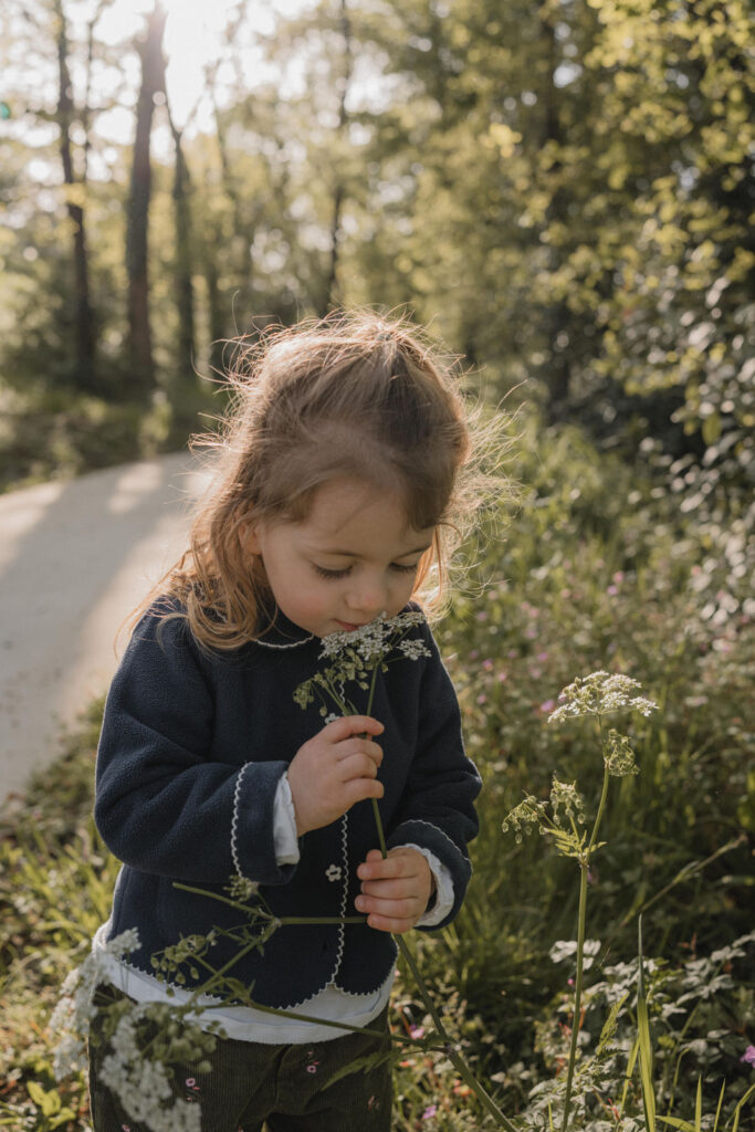 Petite fille observant une fleur lors d'une promenade